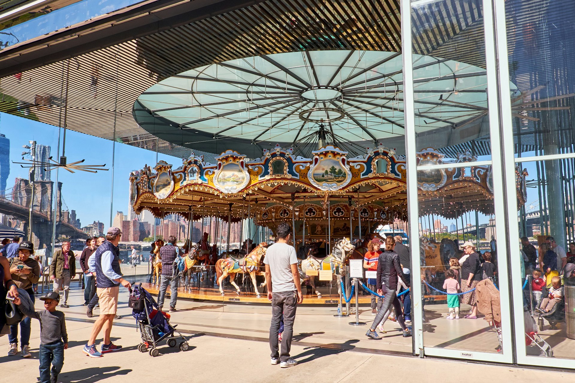 People standing looking at Jane’s Carousel in Brooklyn Bridge Park, Dumbo, Brooklyn, New York City, USA