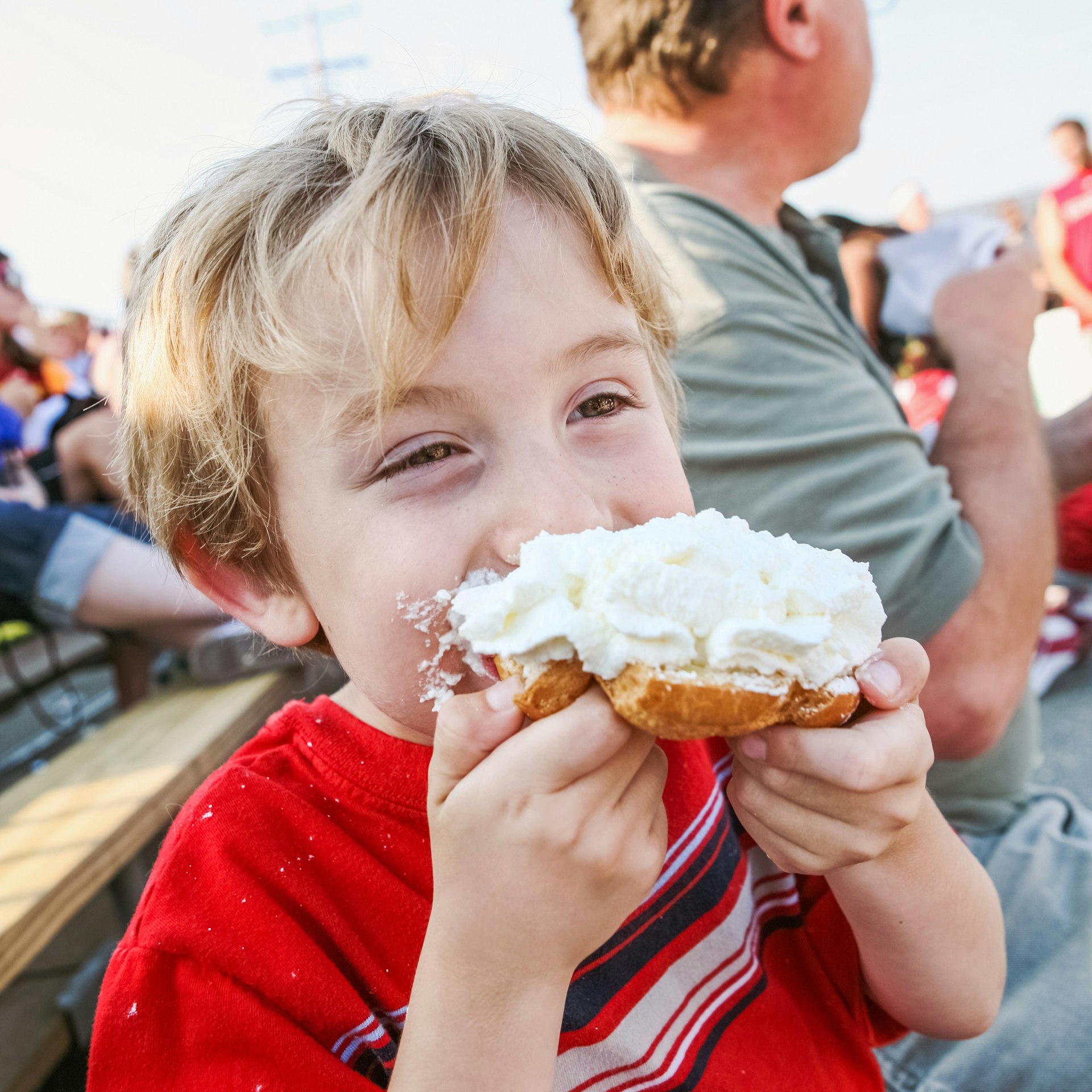 Young boy eating a whipped cream puff pastry at the Wisconsin State Fair, Milwaukee, Wisconsin, Great Lakes, USA