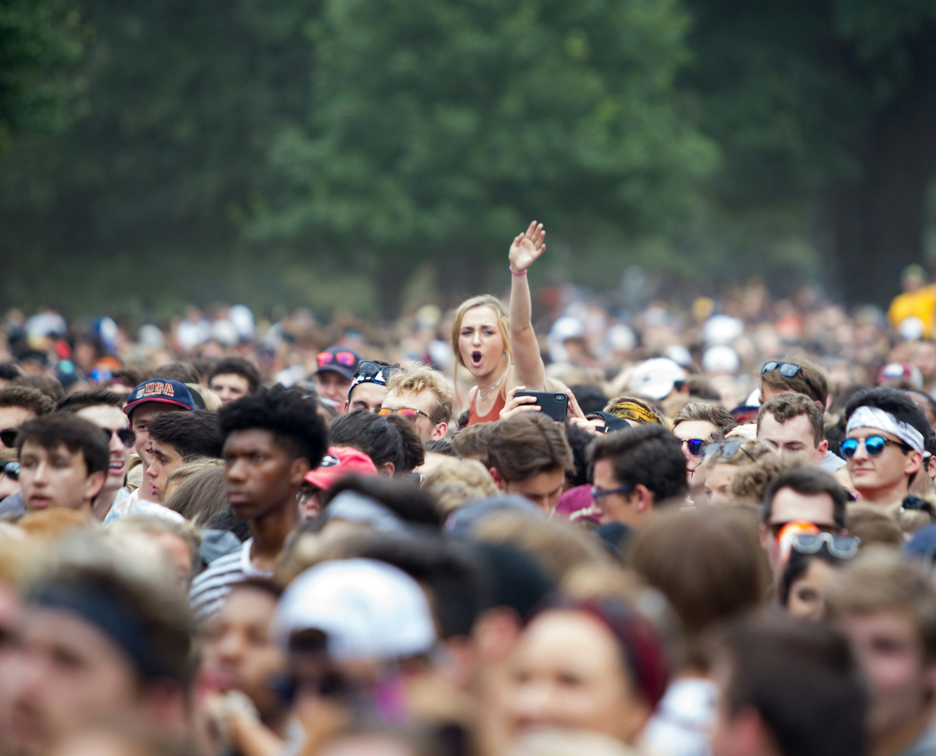 A woman is hoisted above a dense crowd at Music Midtown festival in Piedmont Park, Atlanta, Georgia, USA