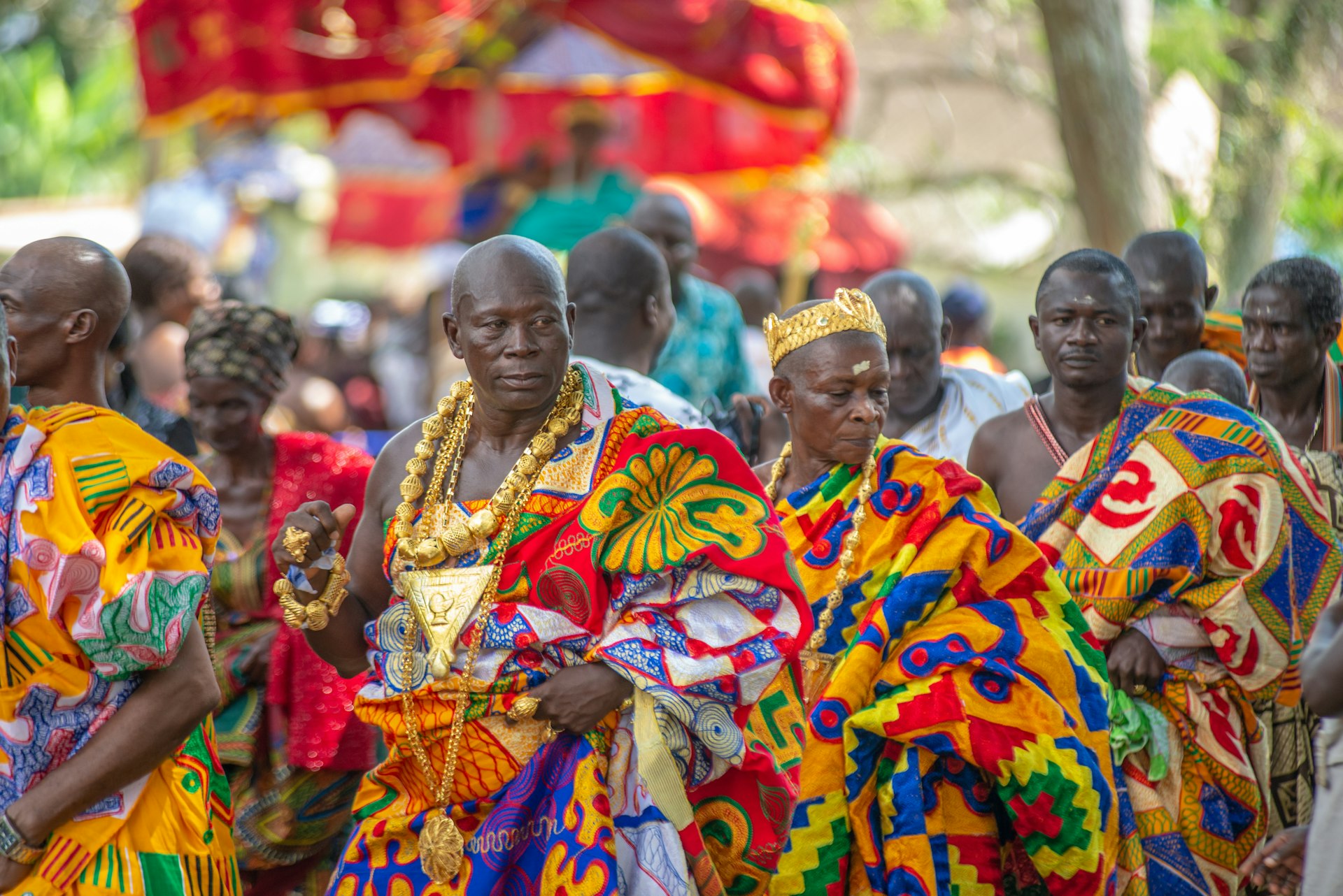 Leaders in brightly colored regalia and kente cloth process during the Odwira Festival in Ghana