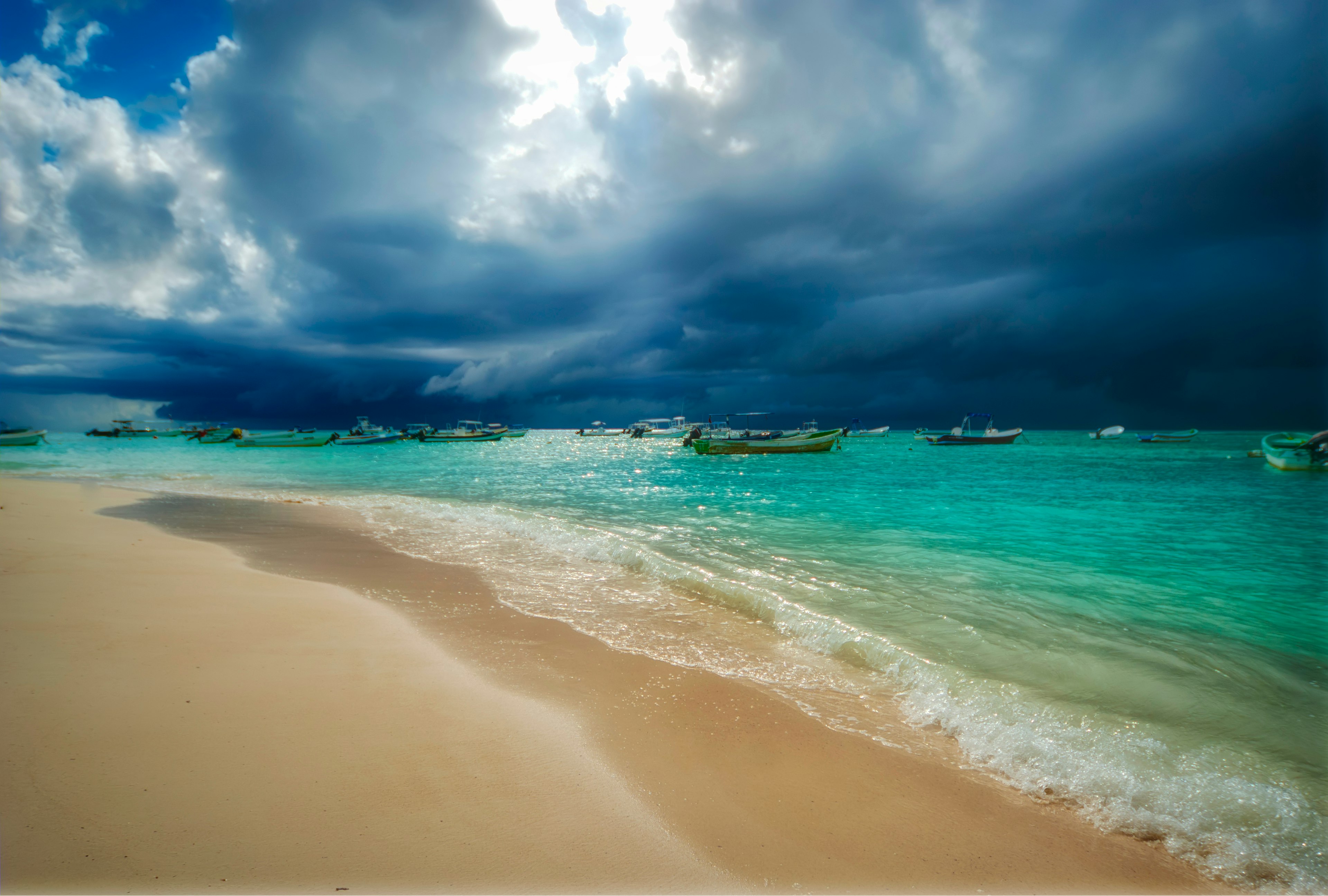 Storm and rain coming to the Caribbean sea of Playa del Carmen Mexico. Fishing boats anchored near the beach; Shutterstock ID 1589015776; your: Brian Healy; gl: 65050; netsuite: Lonely Planet Online Editorial; full: Best time to visit Playa del Carmen