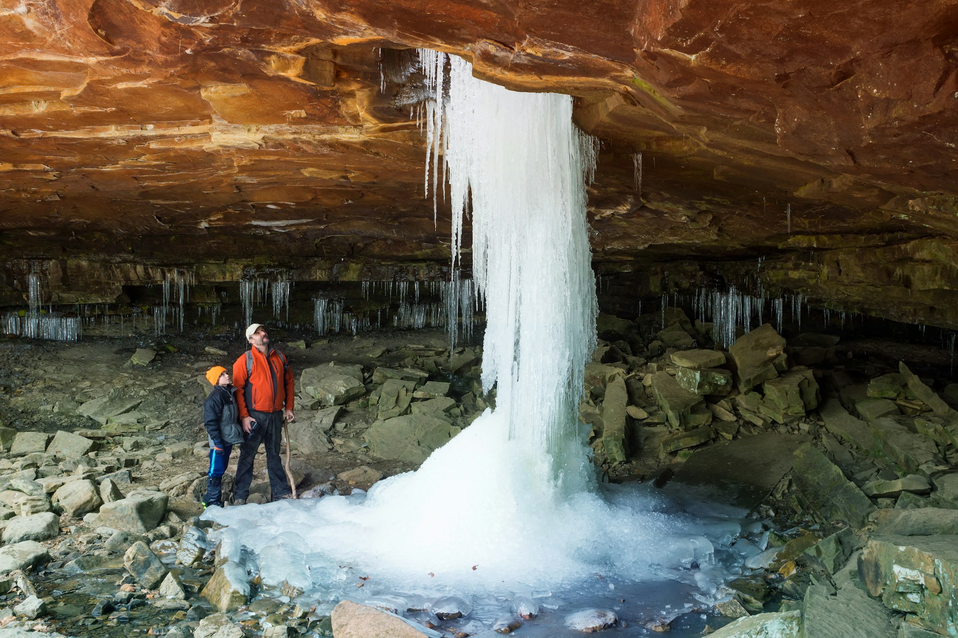 Father and son looking at the frozen waterfall at Glory Hole Falls, Arkansas, USA