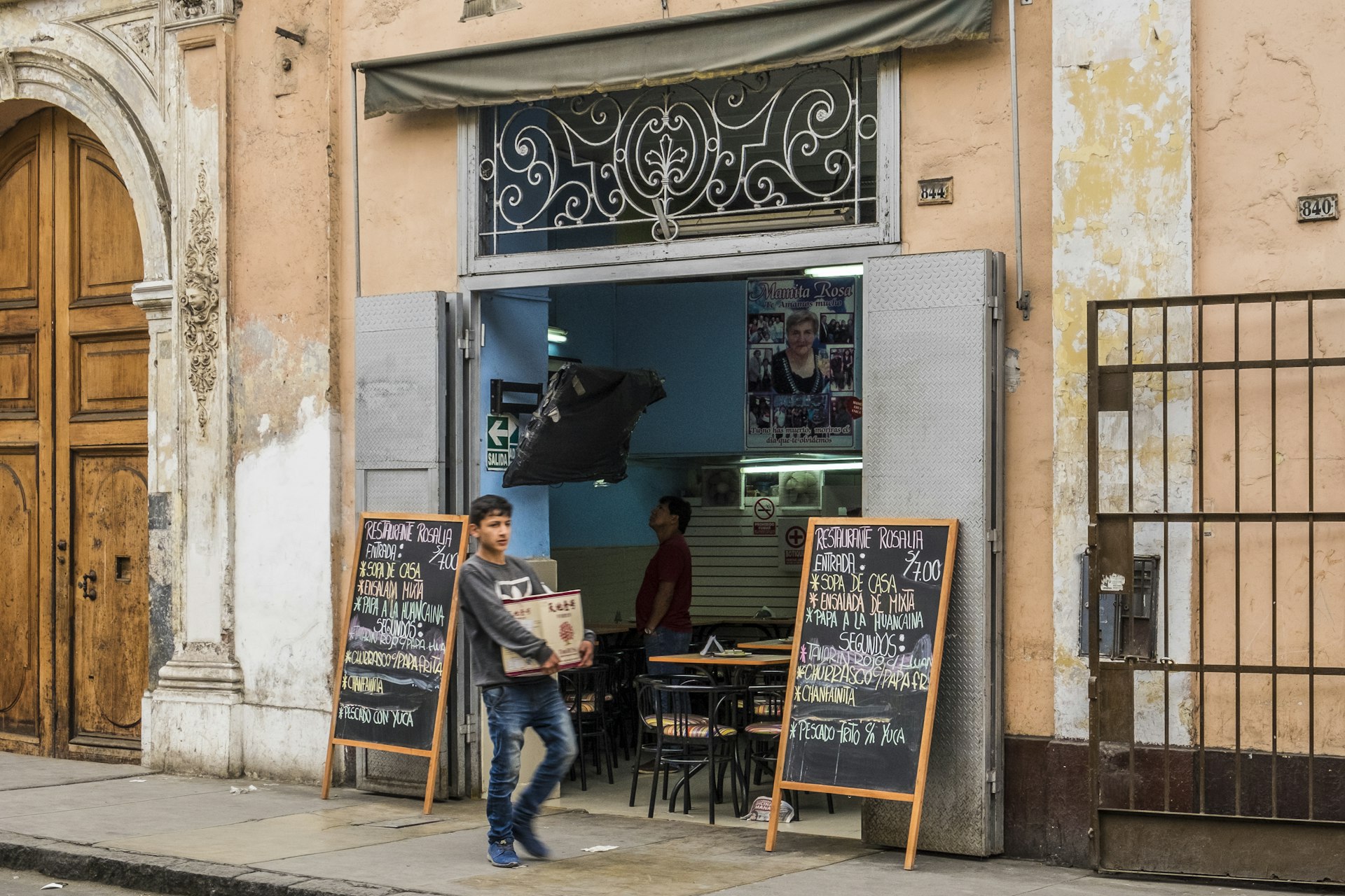 A boy walks in front of a typical small “menú” restaurant in Historic Center of Lima, popular with diners looking for set-lunch menu