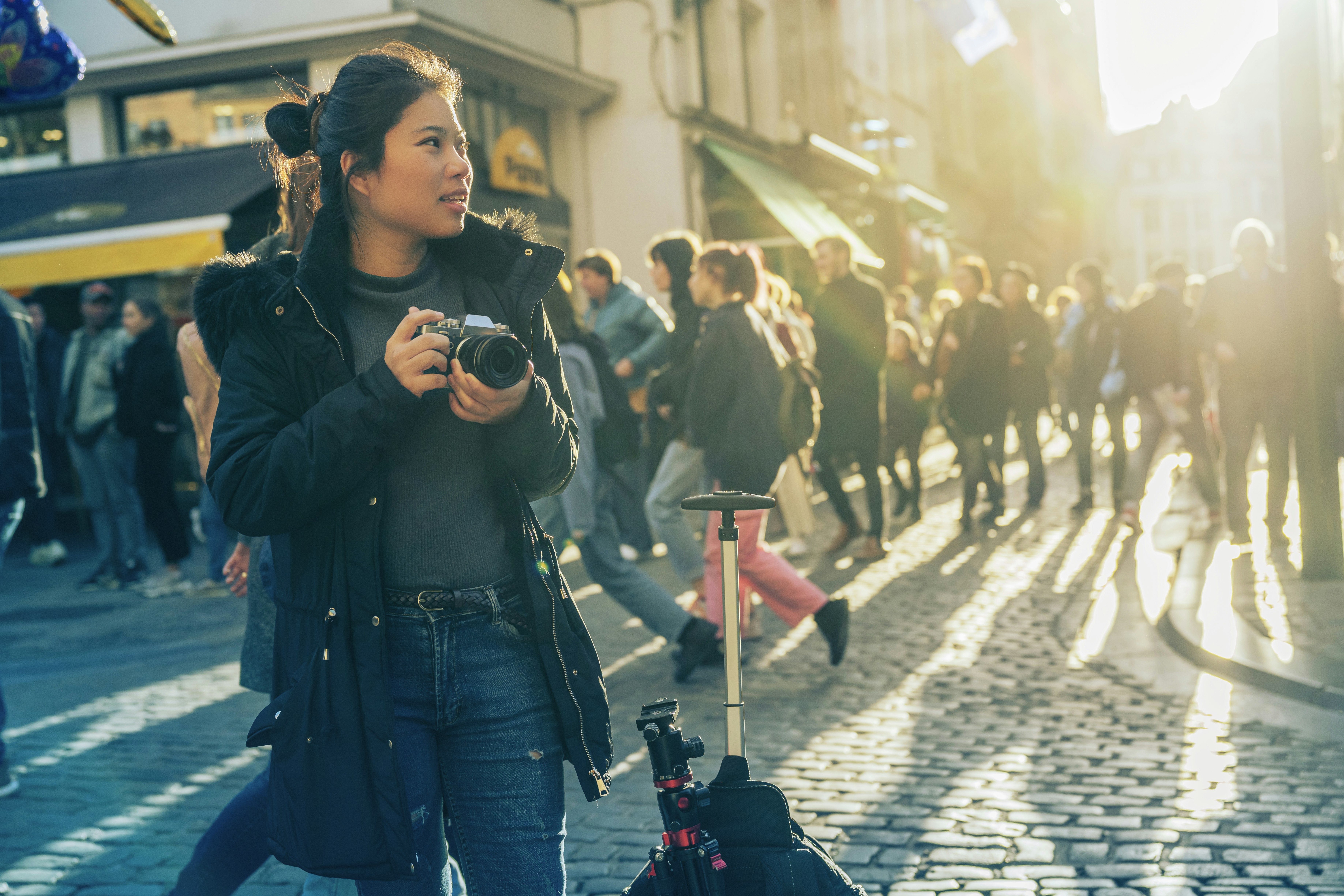 young asian female traveller walking sight seeing hand take photo with camera sunset at street downtown in Brussels, Belgium