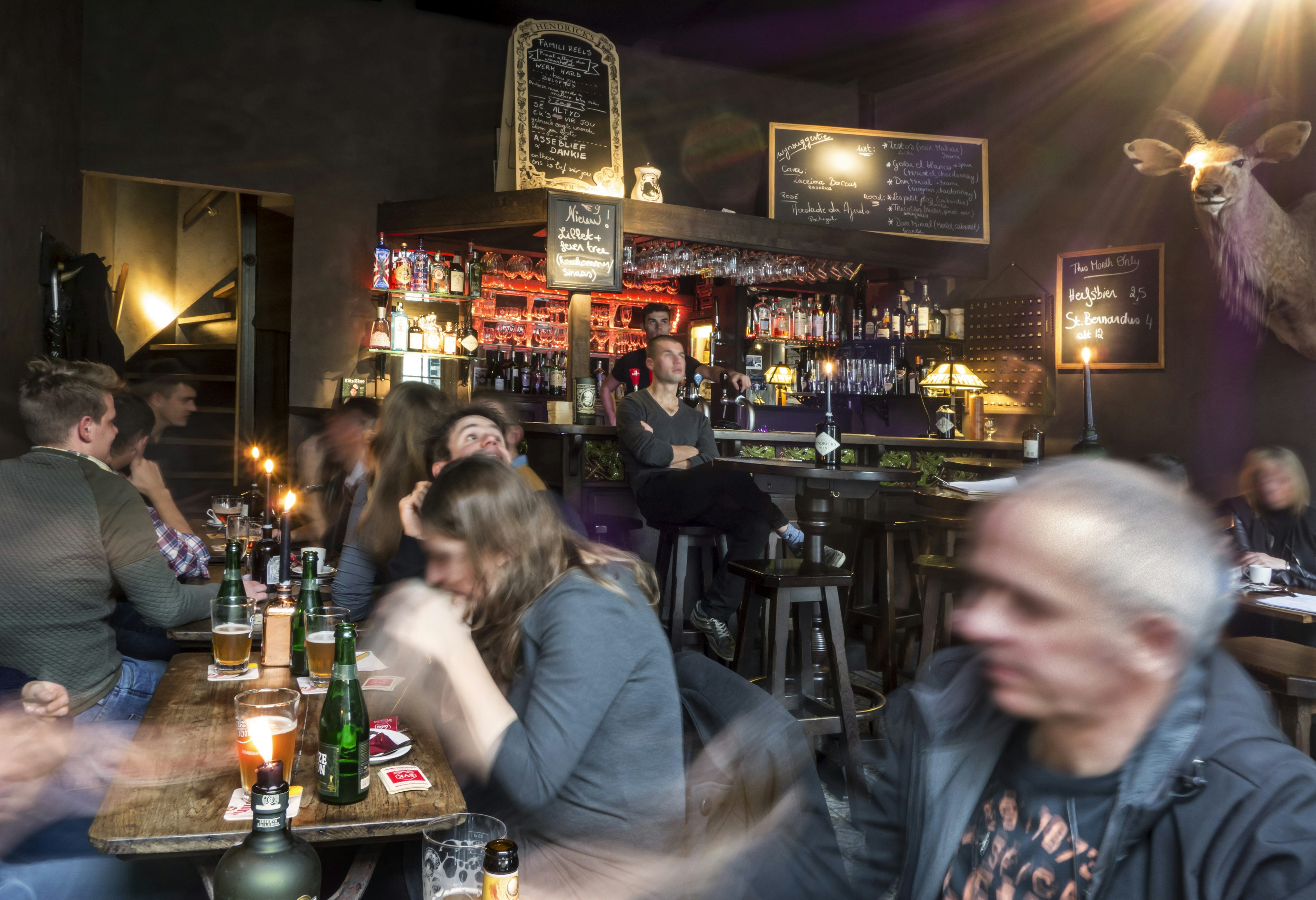 Young people drinking Belgian beer in cosy cafe in the city Ghent