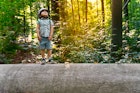 Little toddler standing on a big large elm trunk in a forest in Belgium. Child wearing safety helmet exploring the nature. Sunset in a park.

Hoge Kempen is rich in biodiversity with more than 7000 plant and animal species across 12,000 hectares 