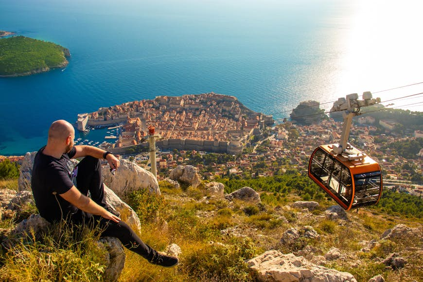 A man watching the cable car arriving at Mt Srđ 