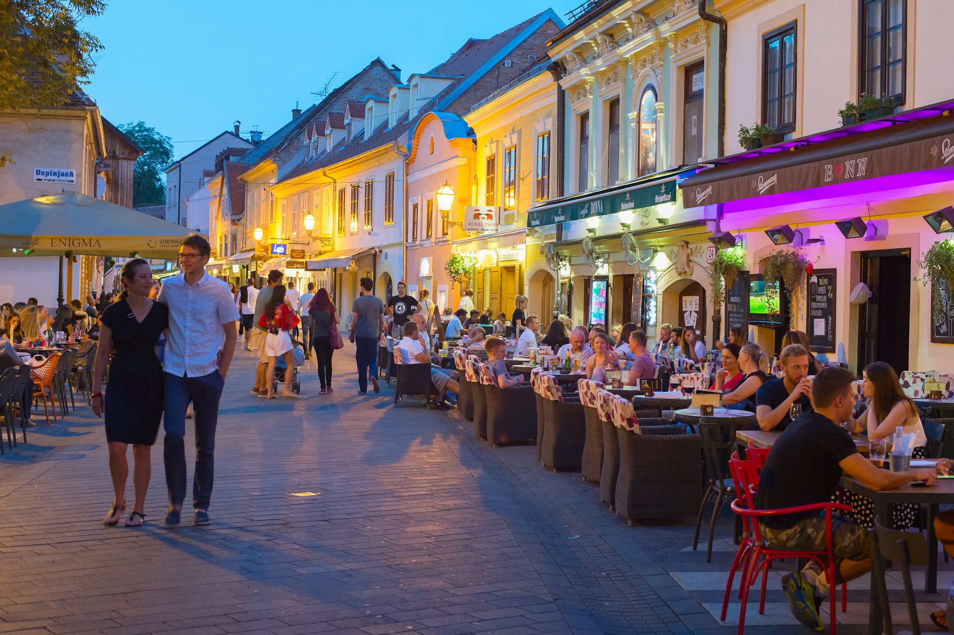 Locals and tourists sit at outdoor terraces along cobblestones Ivana Racica Street at dusk, Zagreb, Croatia