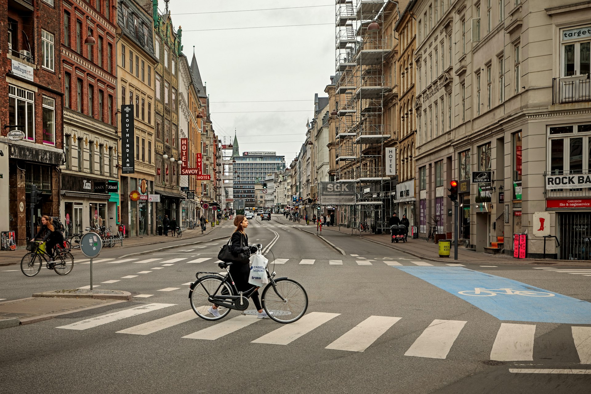 A woman pushing a bicycle along Vesterbrogade in Copenhagen