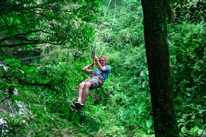 A man ziplines down a rope in over a jungle canopy in El Valle, Panama. 