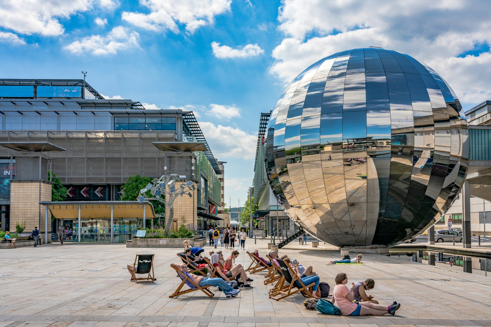 People sit in front of a large disco-ball-like sculpture at the We The Curious Museum in  Bristol