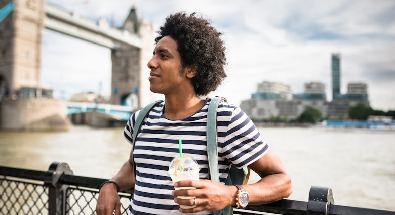 A tourist relaxing in front of Tower Bridge, London