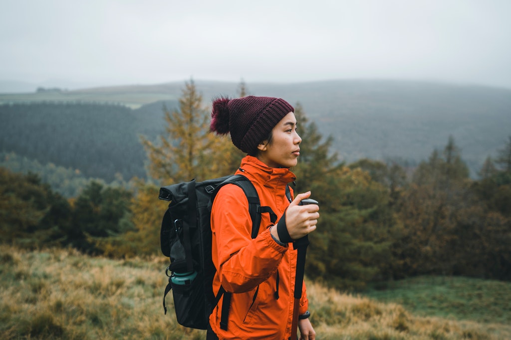 Female with red jacket exploring trekking in mountain National Park; Shutterstock ID 1986990029; your: Claire Naylor; gl: 65050; netsuite: Online ed; full: Peak District things to do