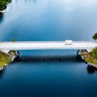 Aerial view Caravan trailer or Camper rv on the bridge over the lake in Finland. Summer holiday trip.; Shutterstock ID 1951837498; your: Brian Healy; gl: 65050; netsuite: Lonely Planet Online Editorial; full: Best road trips in Finland
