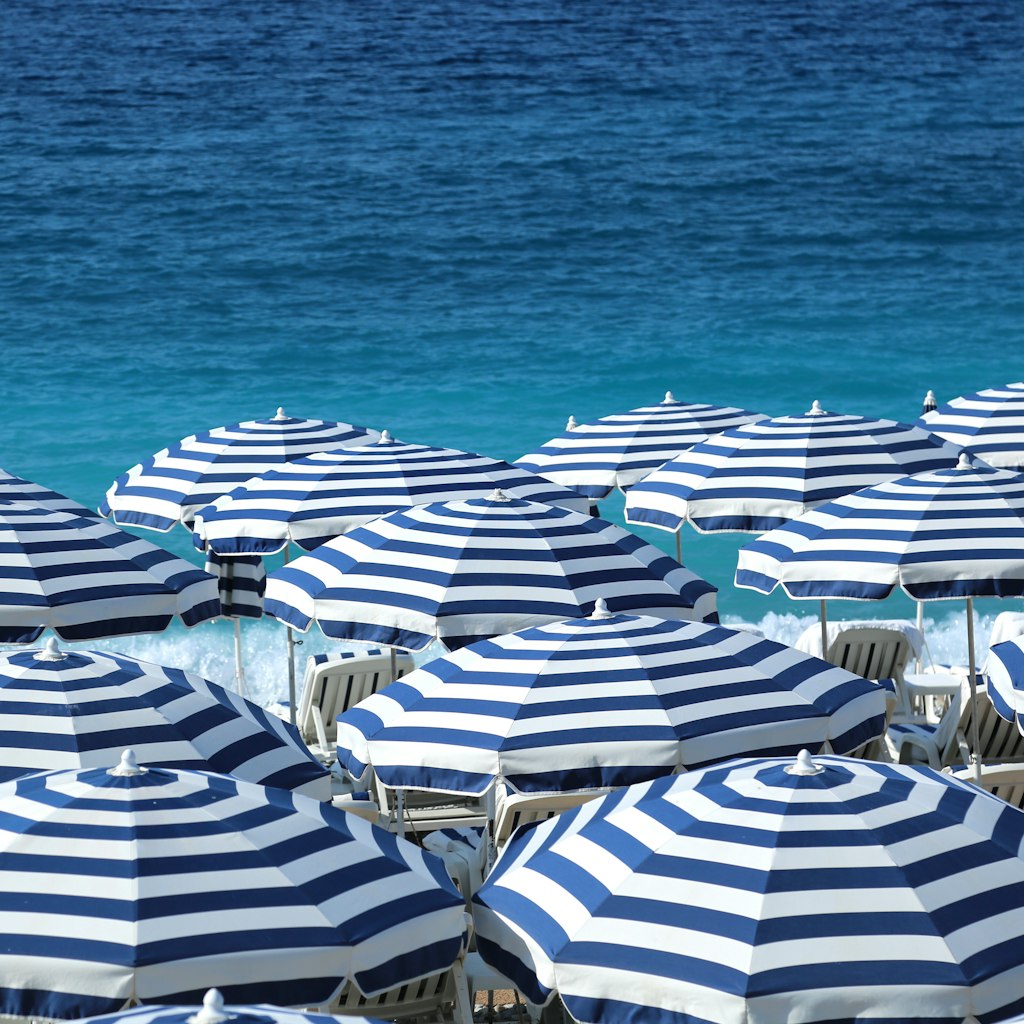 Striped beach umbrellas. Nice, France.; Shutterstock ID 689336932; your: Brian Healy; gl: 65050; netsuite: Lonely Planet Online Editorial; full: Best beaches in Nice