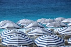 Striped beach umbrellas. Nice, France.; Shutterstock ID 689336932; your: Brian Healy; gl: 65050; netsuite: Lonely Planet Online Editorial; full: Best beaches in Nice