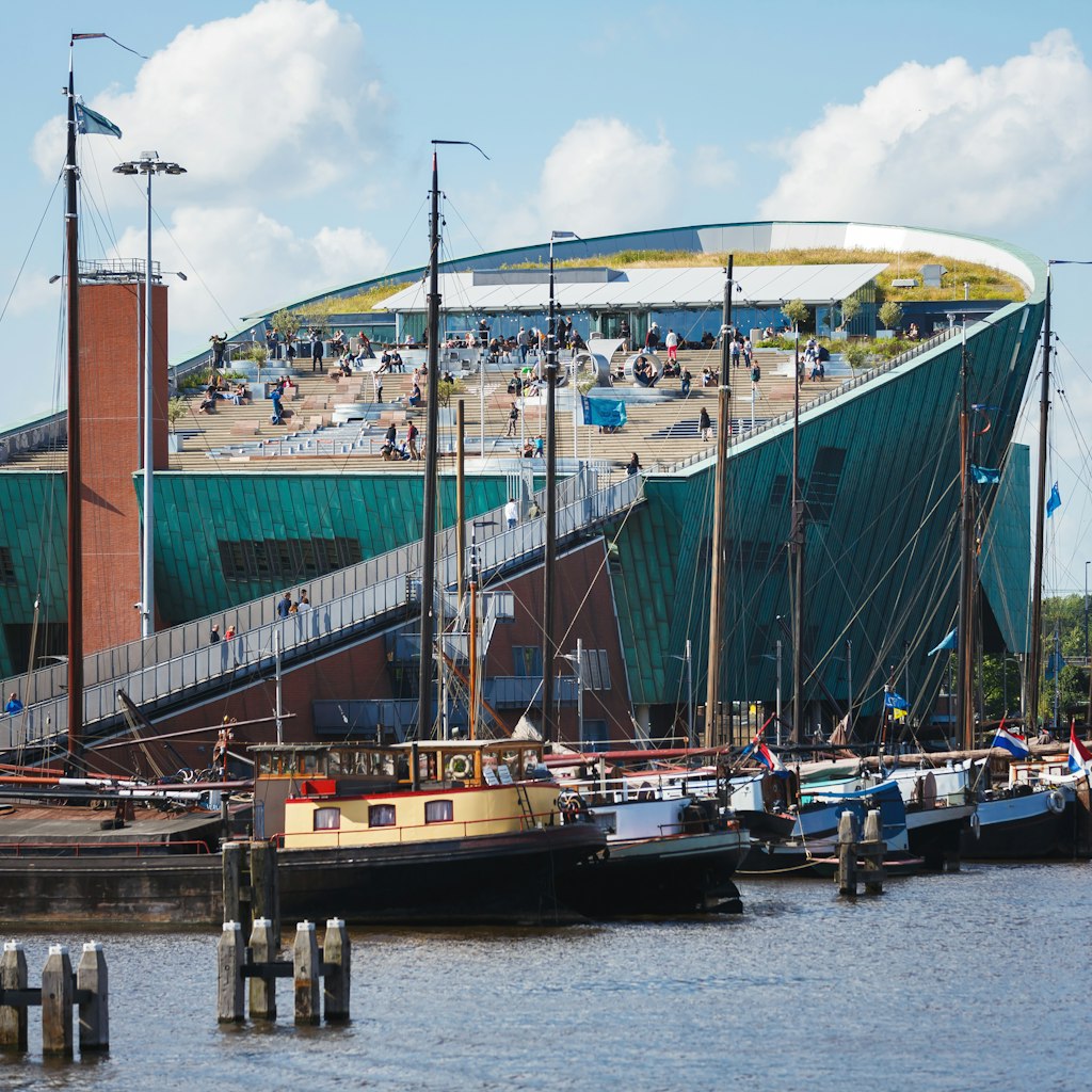 NEMO Science Museum, Amsterdam - stock photo
Amsterdam, Netherlands - July 2, 2016: Some people visit of NEMO Science museum, view from Oosterdok street, sunny day
