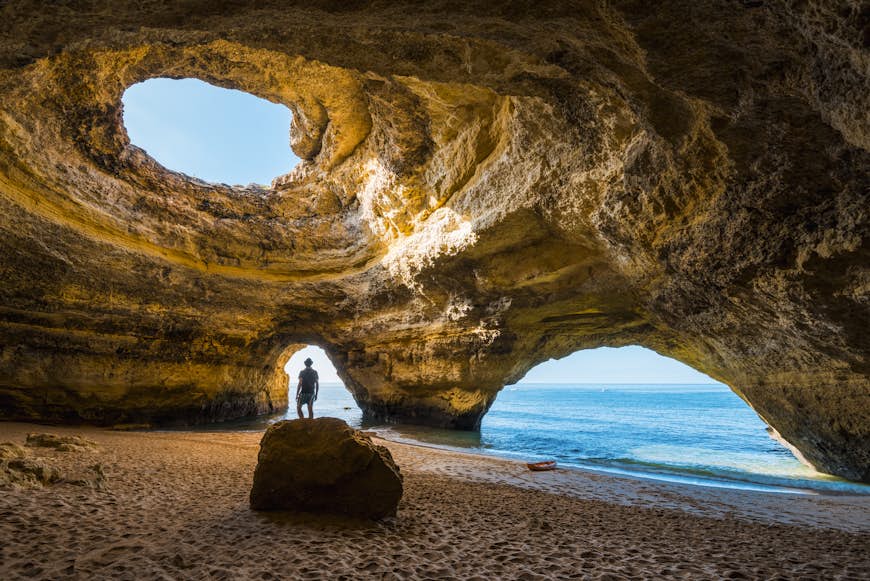 En man tittar upp i öppningen av insidan av Benagil-grottorna, Algarve, Portugal