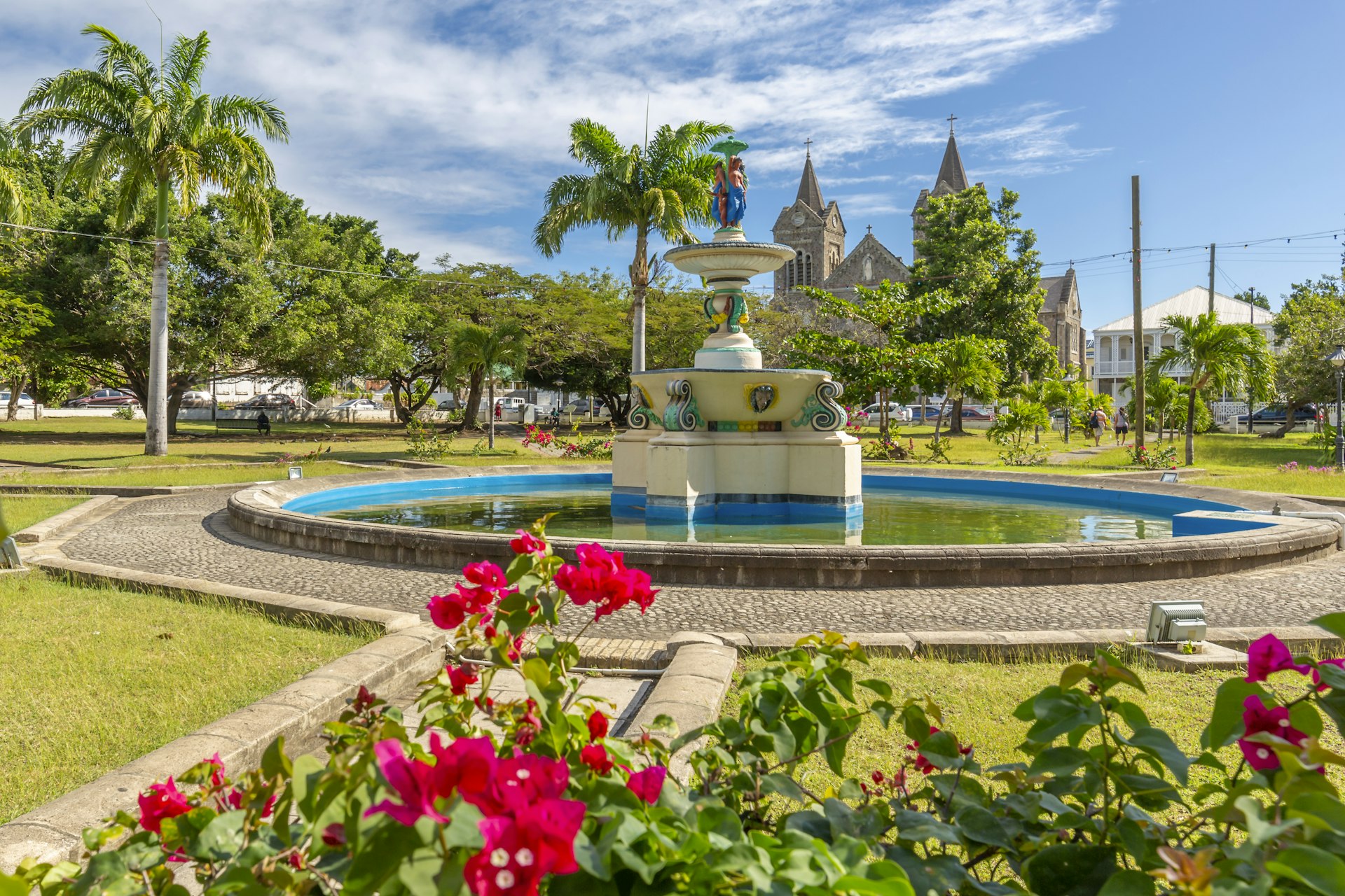 View of flowers and trees around the fountain at Independence Square and Immaculate Conception Catholic Co-Cathedral, Basseterre, St. Kitts