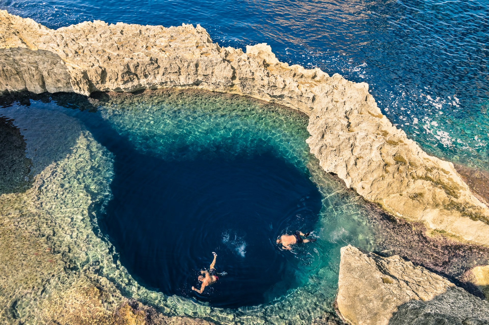 Swimmers at Azure Window arch in Gozo, Malta, Europe