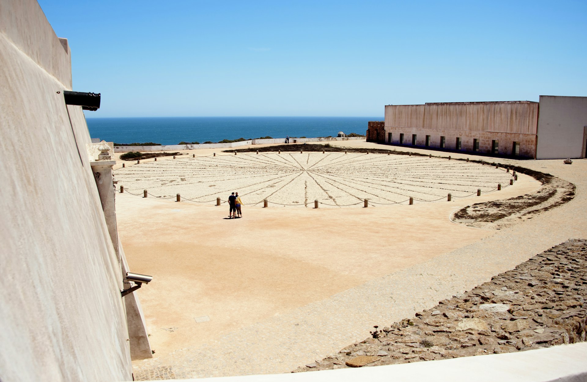 Visitors look at a large compass rose etched into the ground at the Fortaleza de Sagres