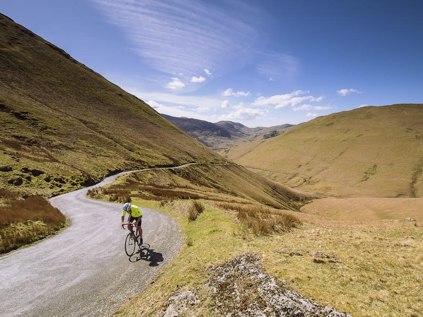 Cycles d'un homme sur une route de montagne de Keswick à Buttermere, Lake District, Cumbria, England, UK