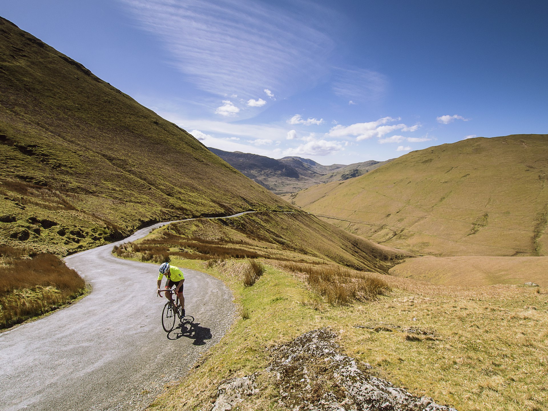 A man cycles on a mountain road from Keswick to Buttermere, Lake District, Cumbria, England, United Kingdom