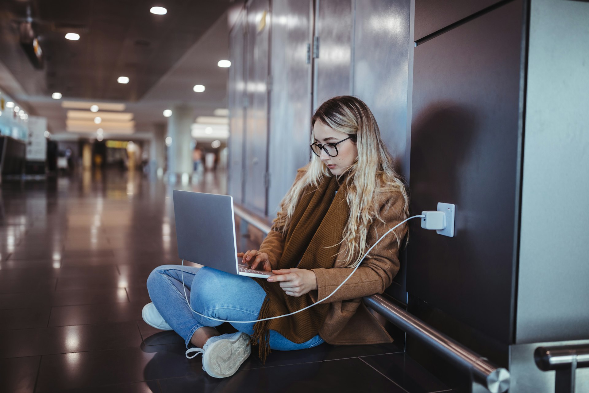 Woman using laptop while waiting for flight departure at airport