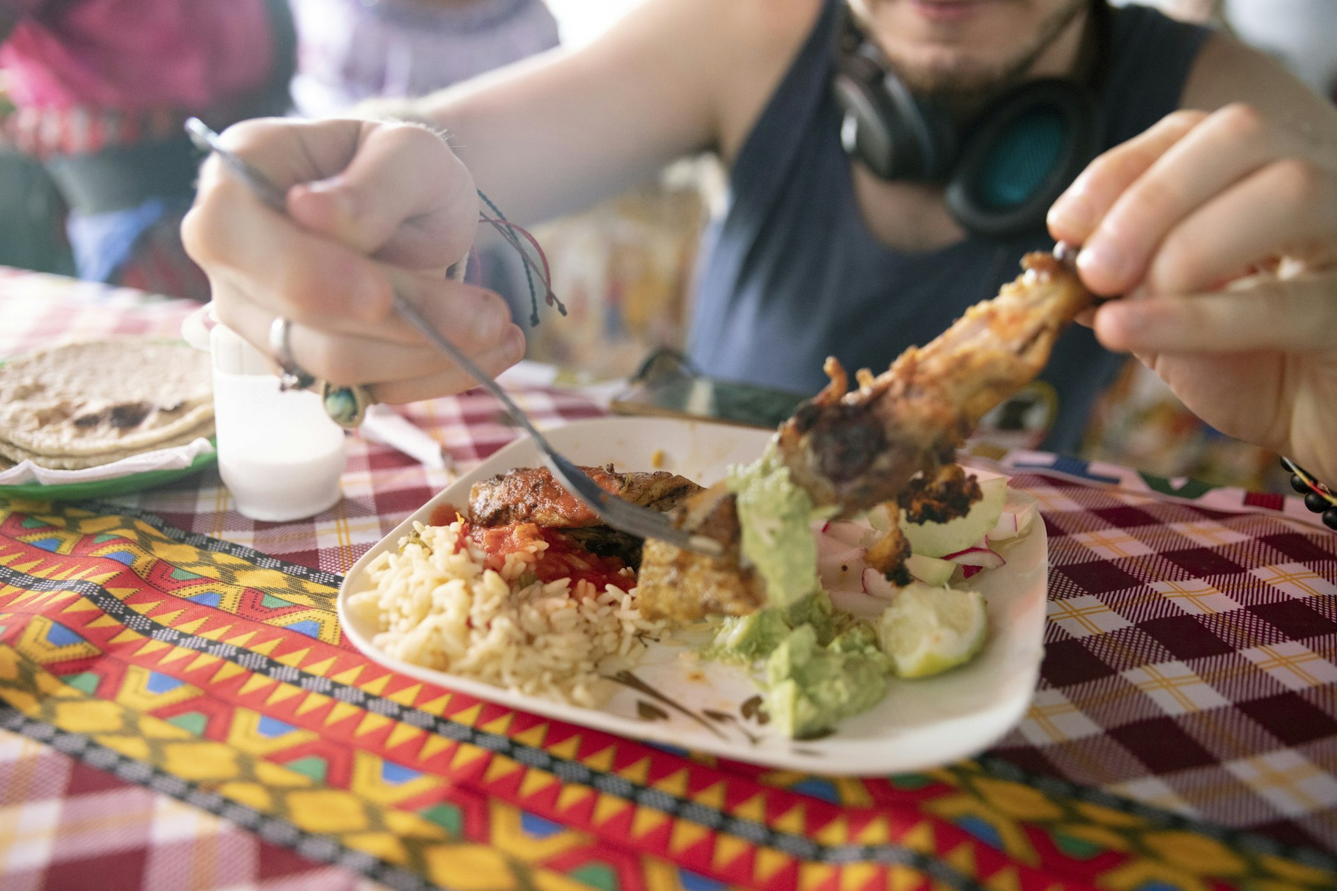 Traveler trying dish of chicken rice and guacamole served at a street food stall in Guatemala