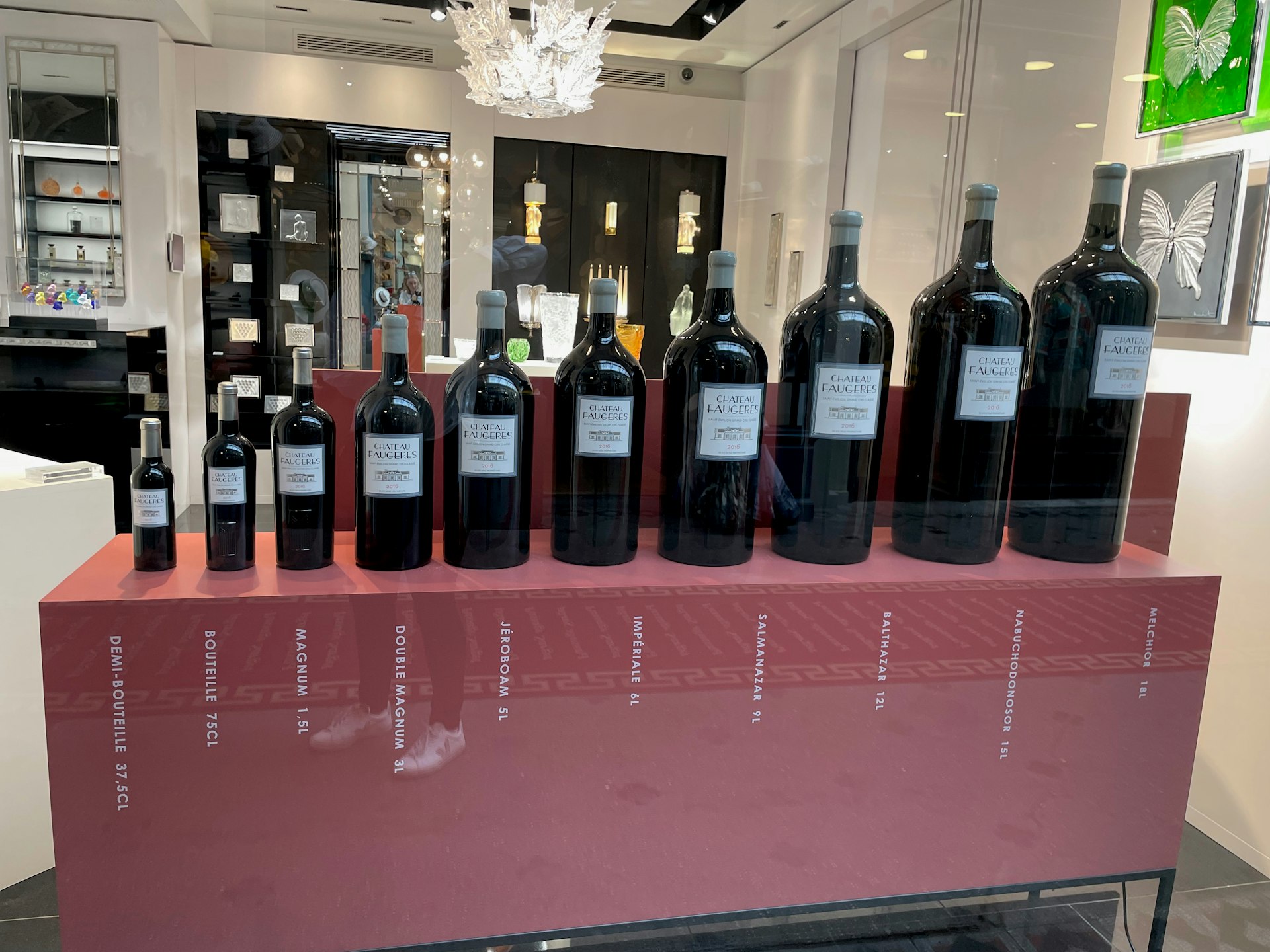 Different sized wines in store window in Bordeaux, France.