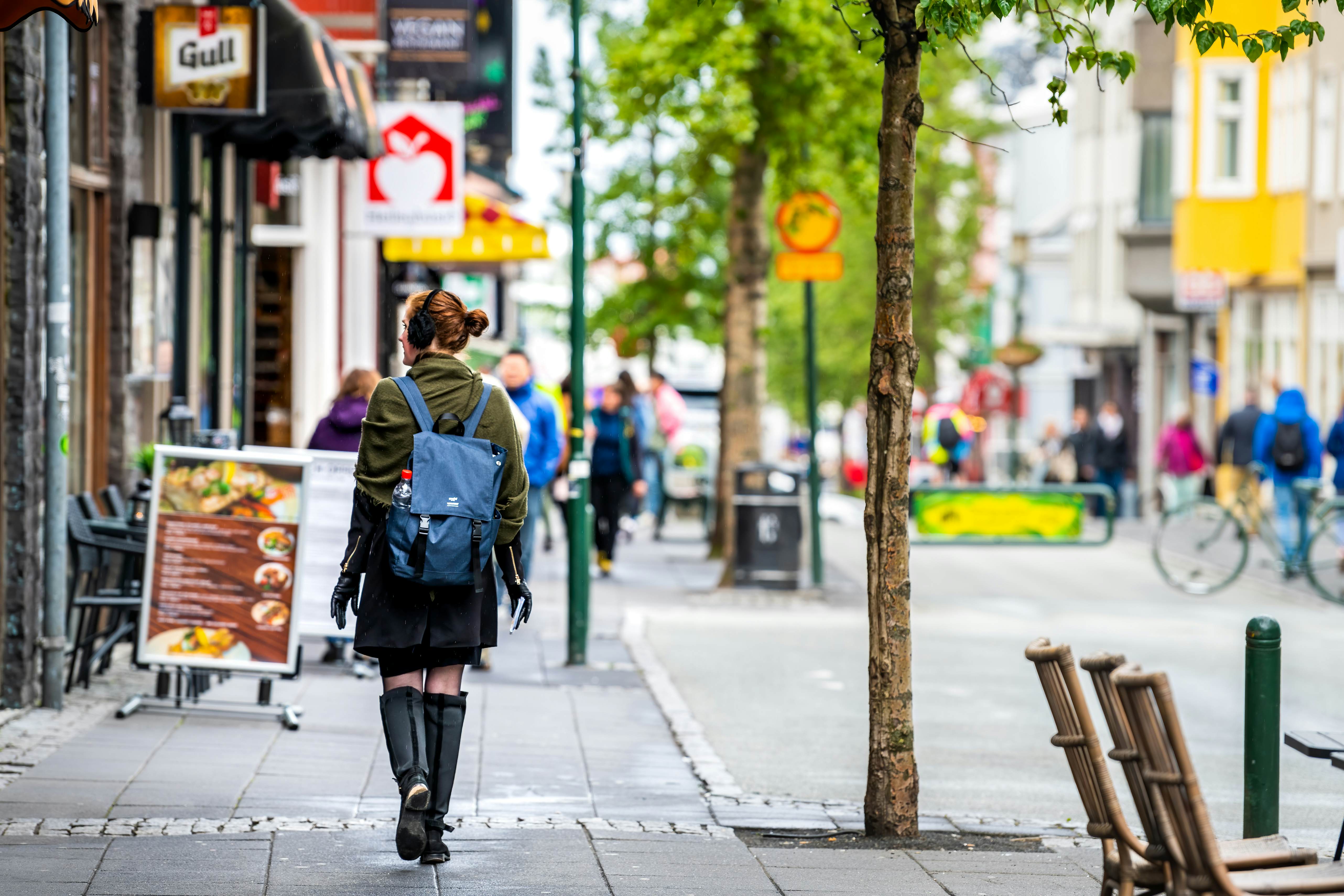 A person walks down the sidewalk of the Laugavegur shopping avenue in Reykjavík