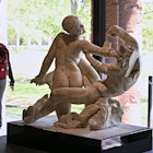 A vistor walks next to a "Satyr and hermaphrodite" sculpture, in Pompeii's site of a new exhibition entitled "Art and sensuality in the houses of Pompeii" on art and sexuality in the ancient city, where sculptures and paintings of breasts and buttocks abounded, on April 28, 2022. - Raunchy scenes may redden faces at a new exhibition in Pompeii on art and sexuality in the ancient Roman city, where sculptures and paintings of breasts and buttocks abounded. Archaeologists excavating the city, which was destroyed by the eruption of nearby Vesuvius in 79 AD, were initially startled to discover erotic images everywhere, from garden statues to ceiling frescos. (Photo by Andreas SOLARO / AFP) (Photo by ANDREAS SOLARO/AFP via Getty Images)