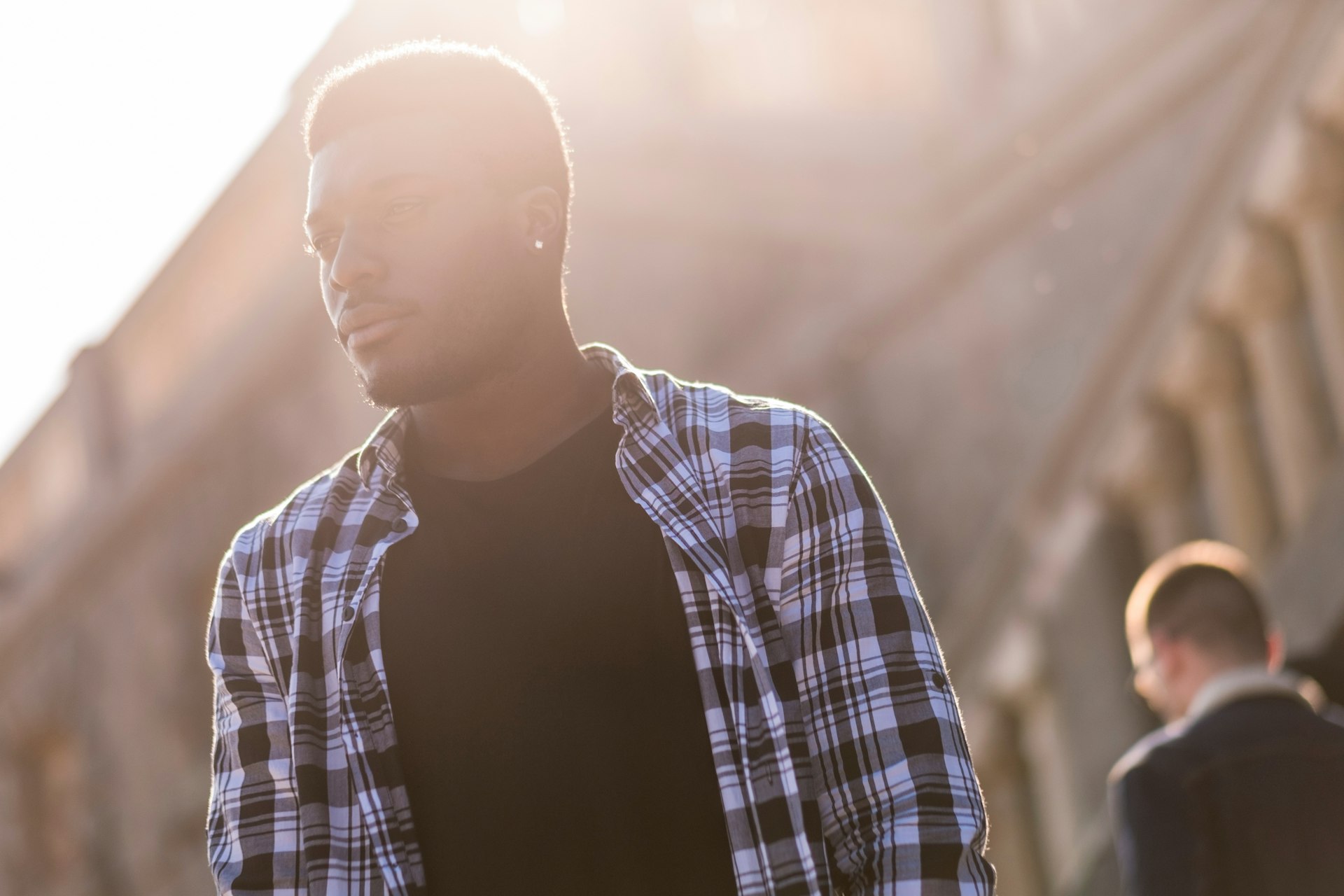 Handsome young black man walks through Turin city centre with sun in the background