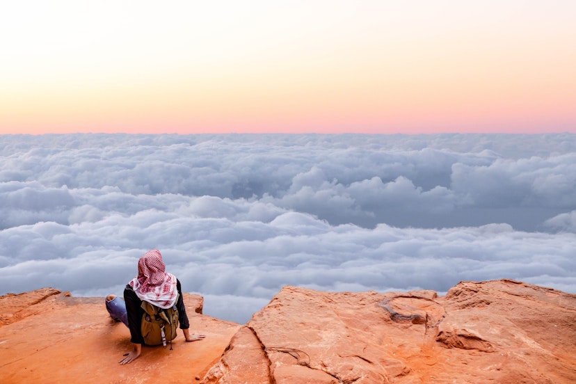 Tourist contemplating the sea of clouds from above with infinity landscape. 