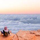 Tourist contemplating the sea of clouds from above with infinity landscape. 