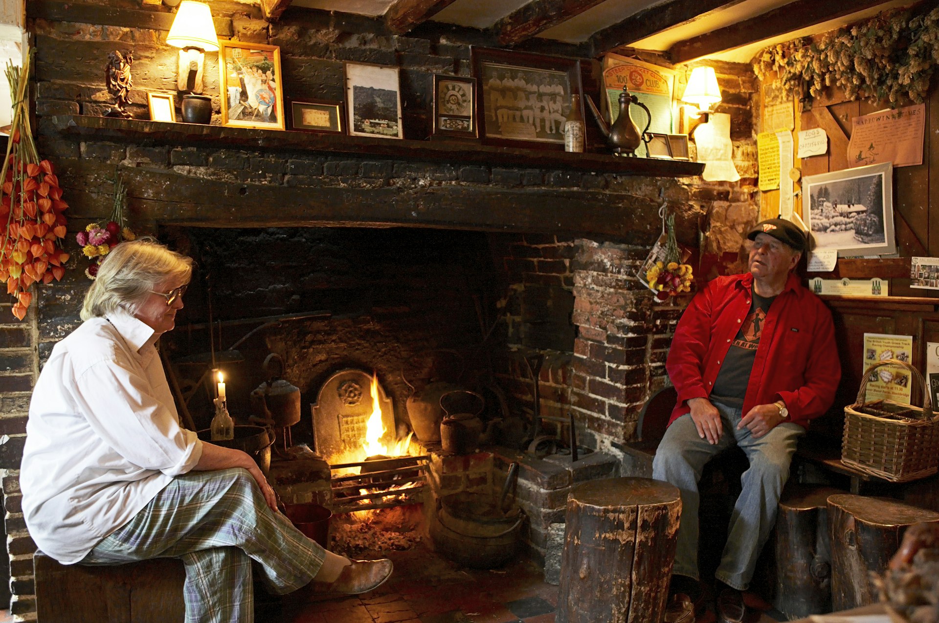 A couple warming up by the fire at an English pub