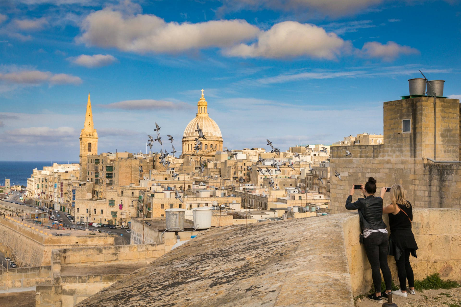 Two women tourists looking at hte skyline of Valletta, Malta 