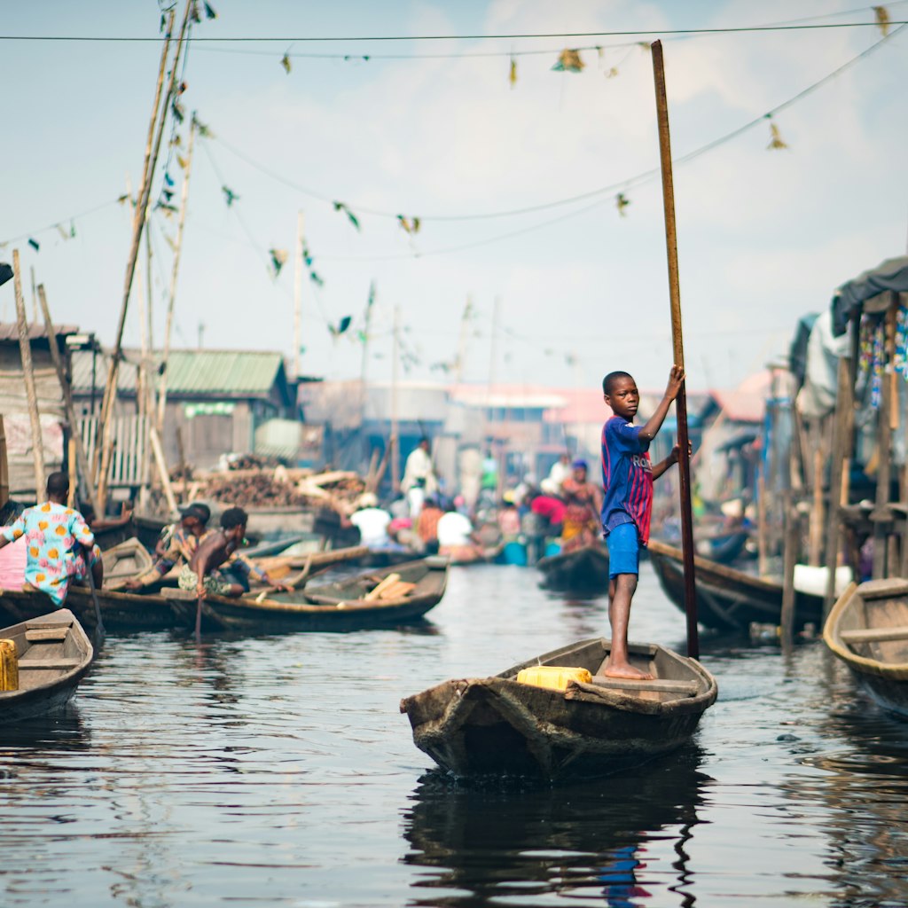 A young boy rowing a Canoe in the Makoko Stilts Village, Lagos/ Nigeria taken on the 18th of May, 2019; Shutterstock ID 1406396870; your: Brian Healy; gl: 65050; netsuite: Lonely Planet Online Editorial; full: Things to know before Lagos