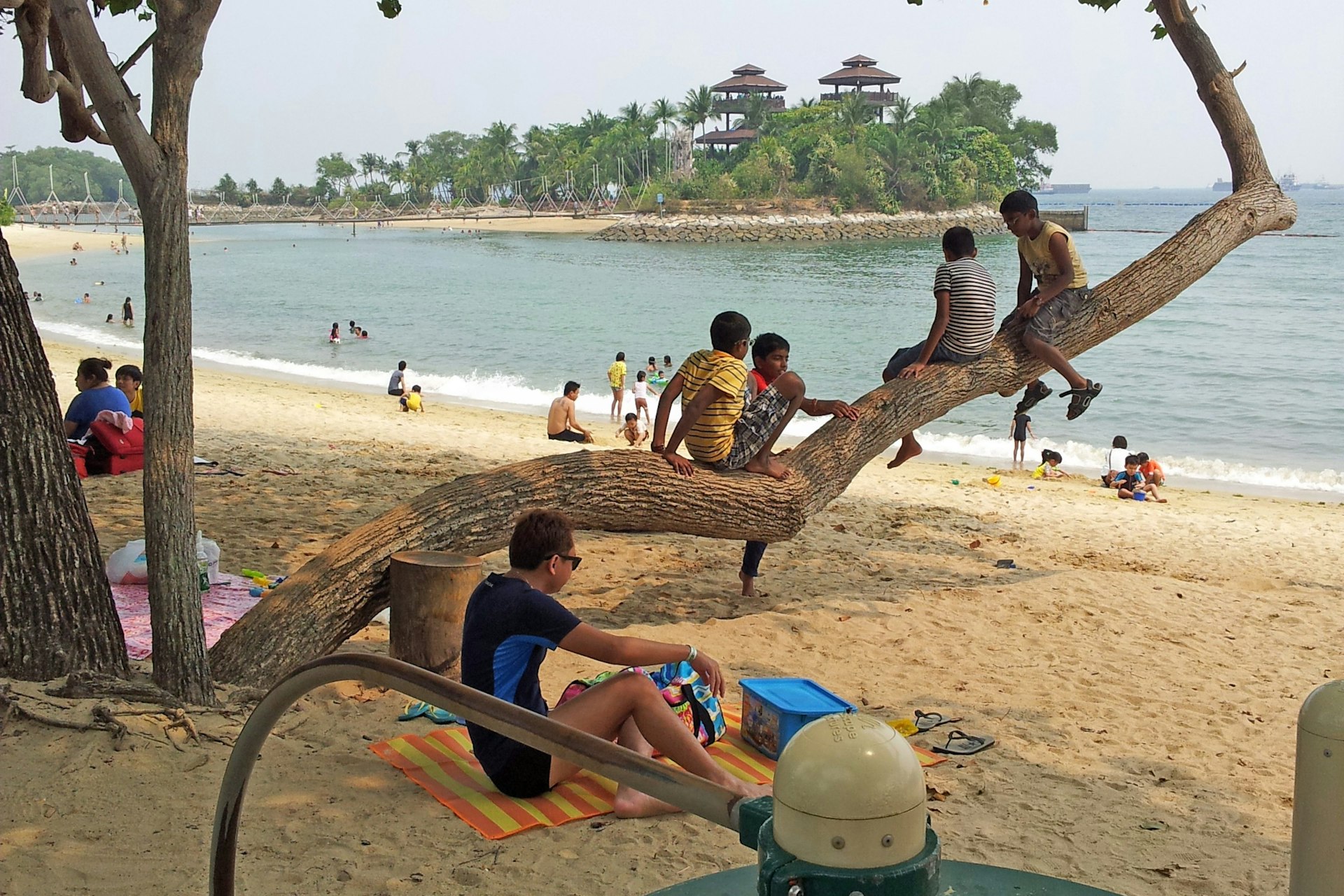 Families on Palawan Beach with Palawan Island in background, Sentosa Island, Singapore