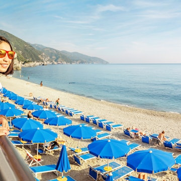 Young traveler asian woman at sandy beach with sunglasses and backpack