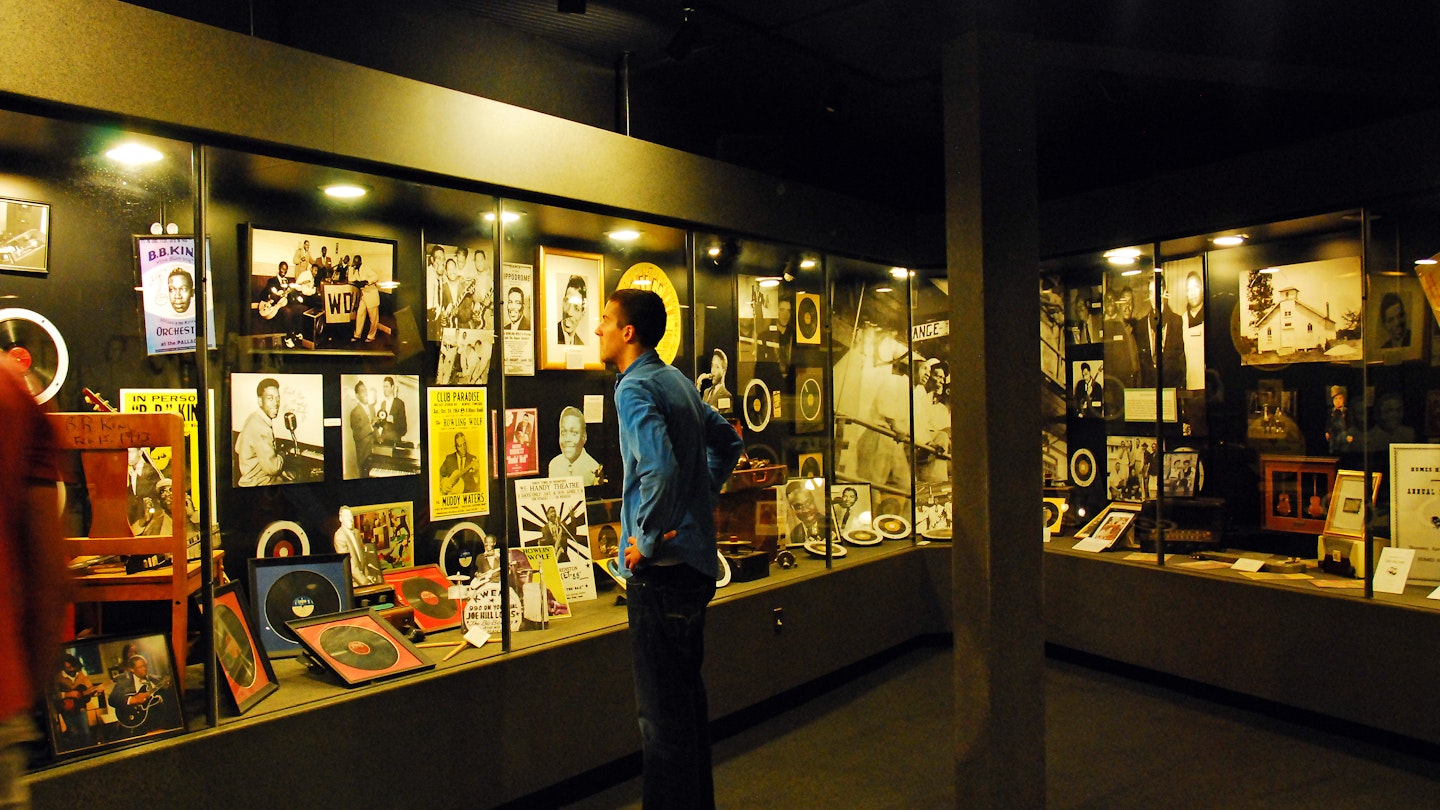 A man looks at old records, posters and photos encased in a large display at Sun Studios in Memphis, TN. 