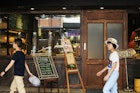 Two people walk past a small cafe in Taipei