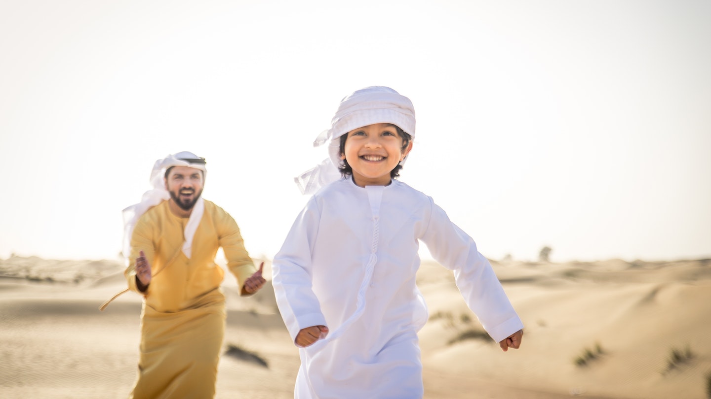 Happy family playing in the desert of Dubai -  Playful father and his son having fun outdoors; Shutterstock ID 1469040209; your: Brian Healy; gl: 65050; netsuite: Lonely Planet Online Editorial; full: Dubai with kids