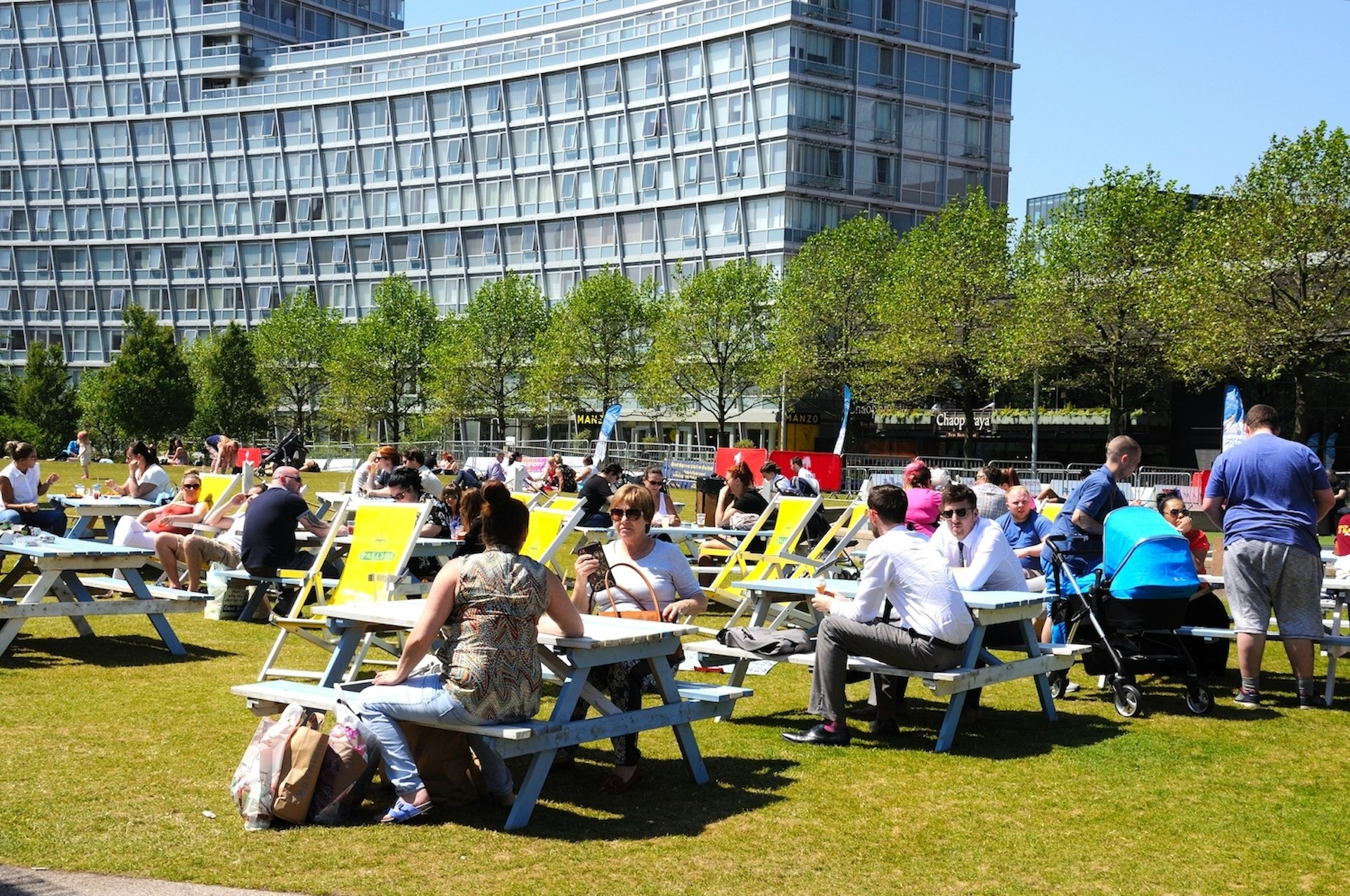 People relaxing at picnic benches in Chavasse Park in summer, Liverpool, Merseyside, England, United Kingdom, Western Europe