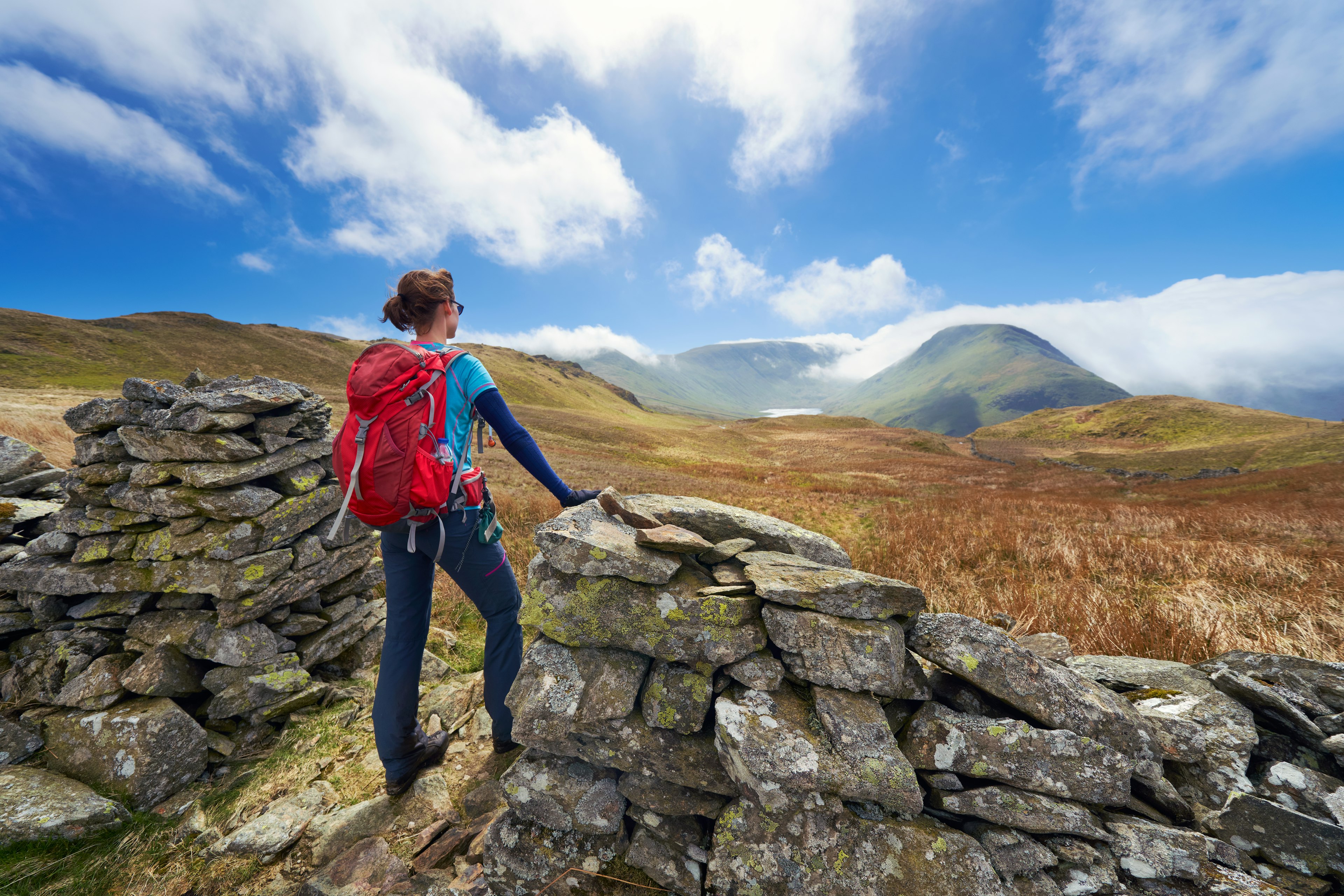 A female hiker taking in the mountain views of Hayeswater, Lake District, UK