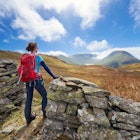 A female hiker taking in the mountain views of Hayeswater, Lake District, UK