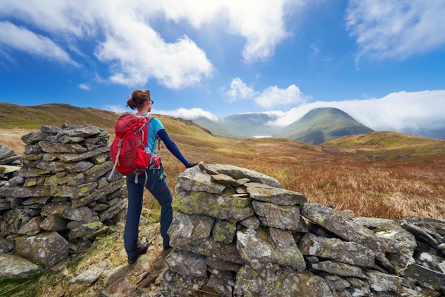 A female hiker taking in the mountain views of Hayeswater, Lake District, UK