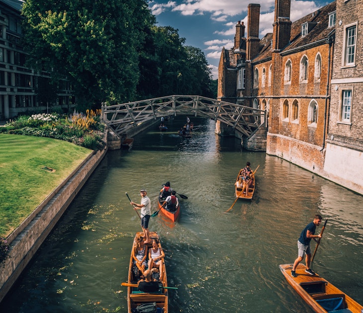 Cambridge, UK - August 20, 2017 : People punting in a canal next to the Mathematical bridge
