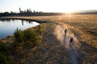 USA, Oregon, Bend, two cyclists on trail by river - stock photo