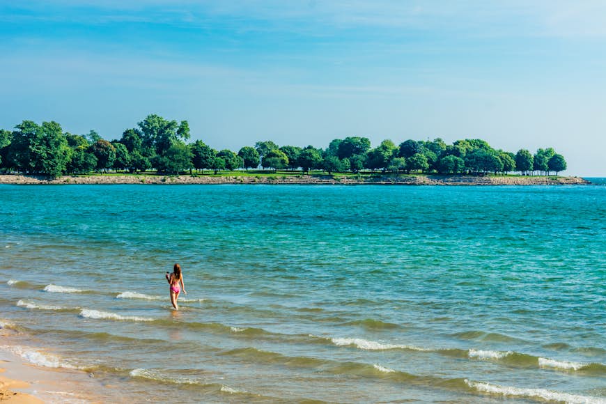 A woman walking in the shallows at 57th Street Beach in Chicago
